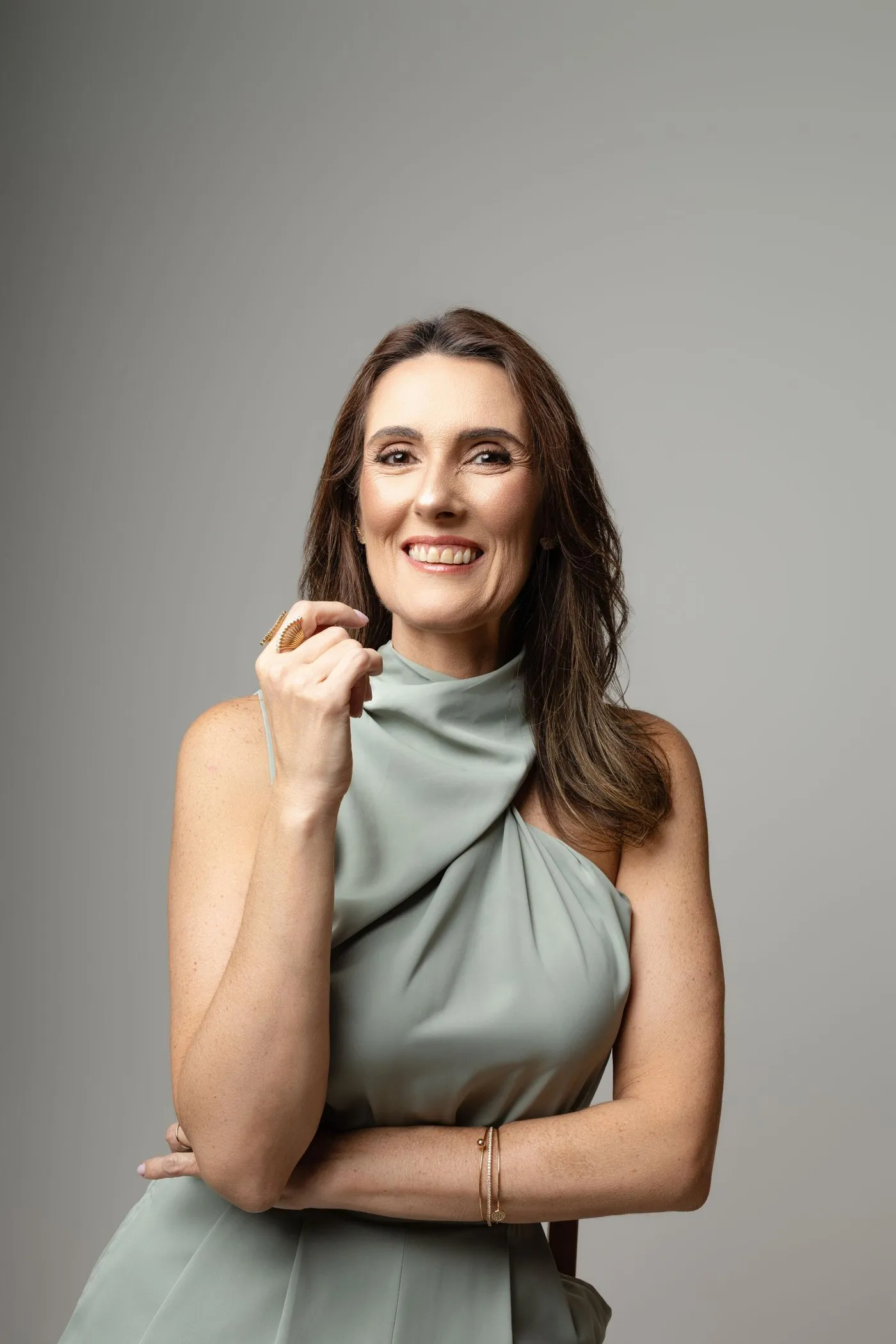 Dra. Jussara Brito sorrindo, com vestido verde-sálvia